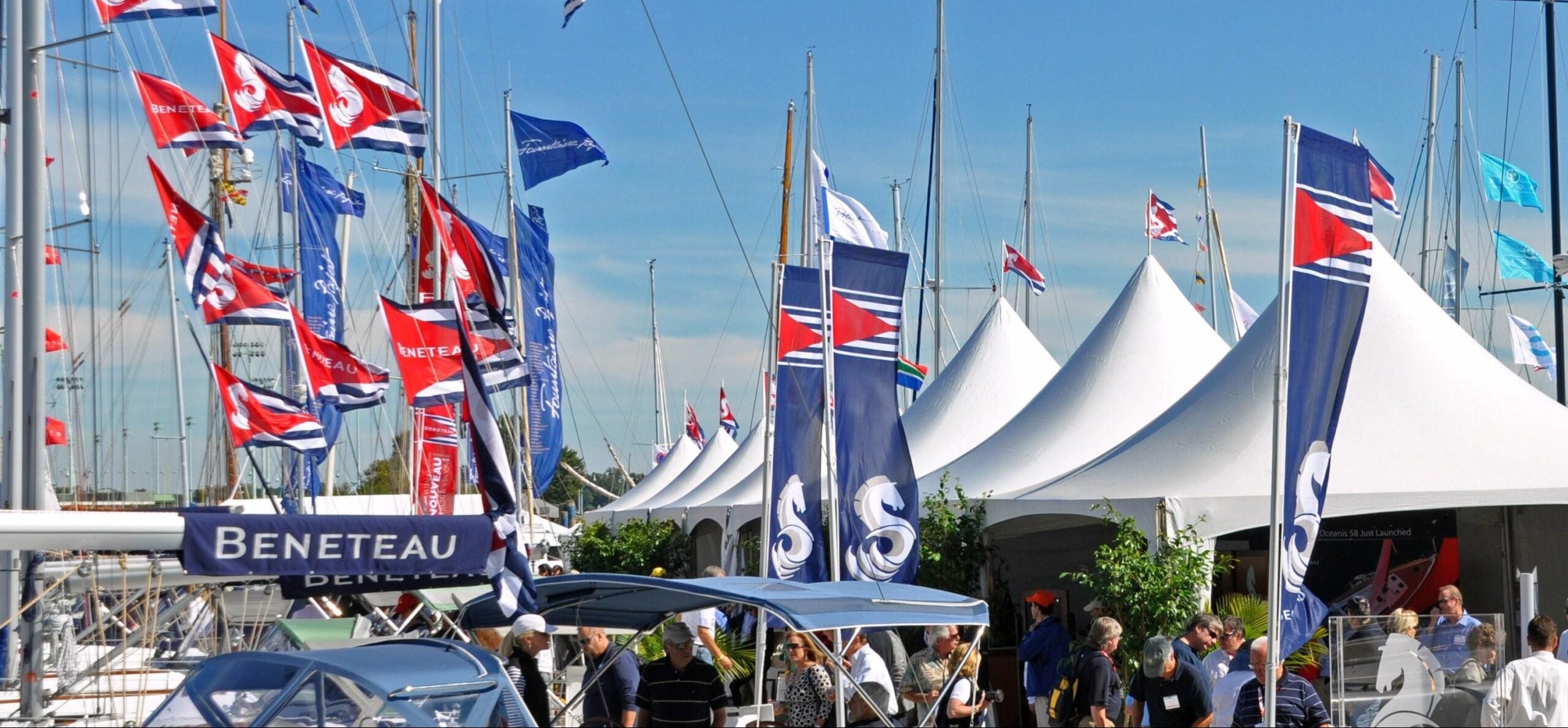 Annapolis Boat Show with Select Event Group tents and flags against a blue sky.